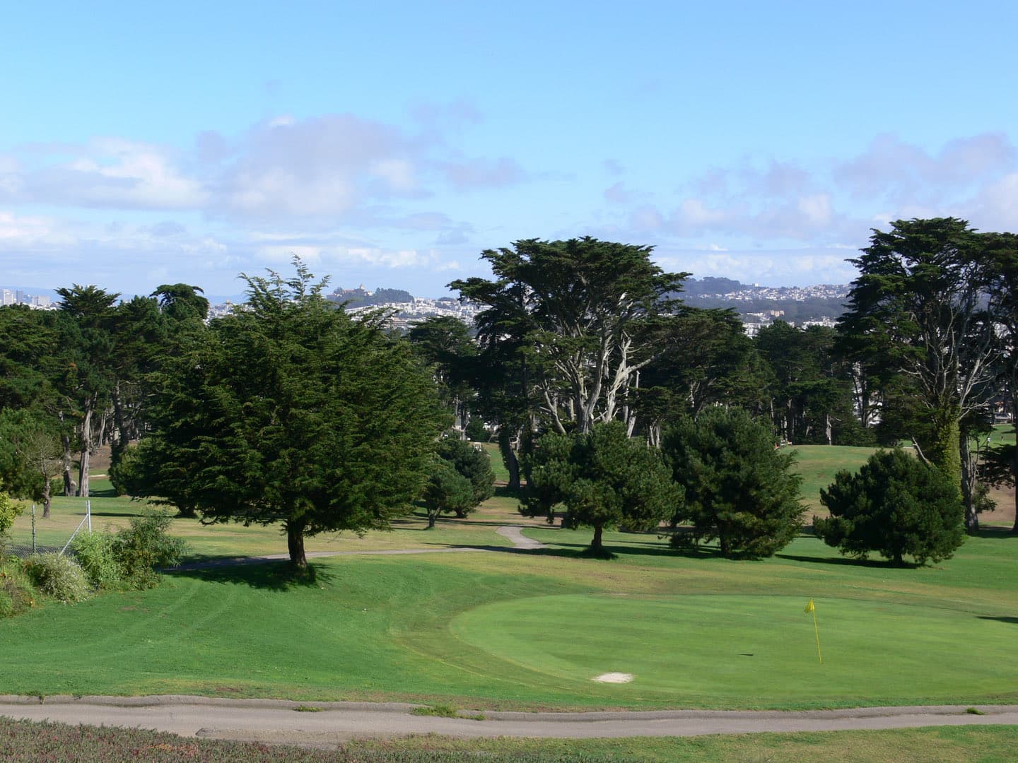 Tree-lined fairways and greens at Lincoln Park Golf Course overlooking San Francisco Bay